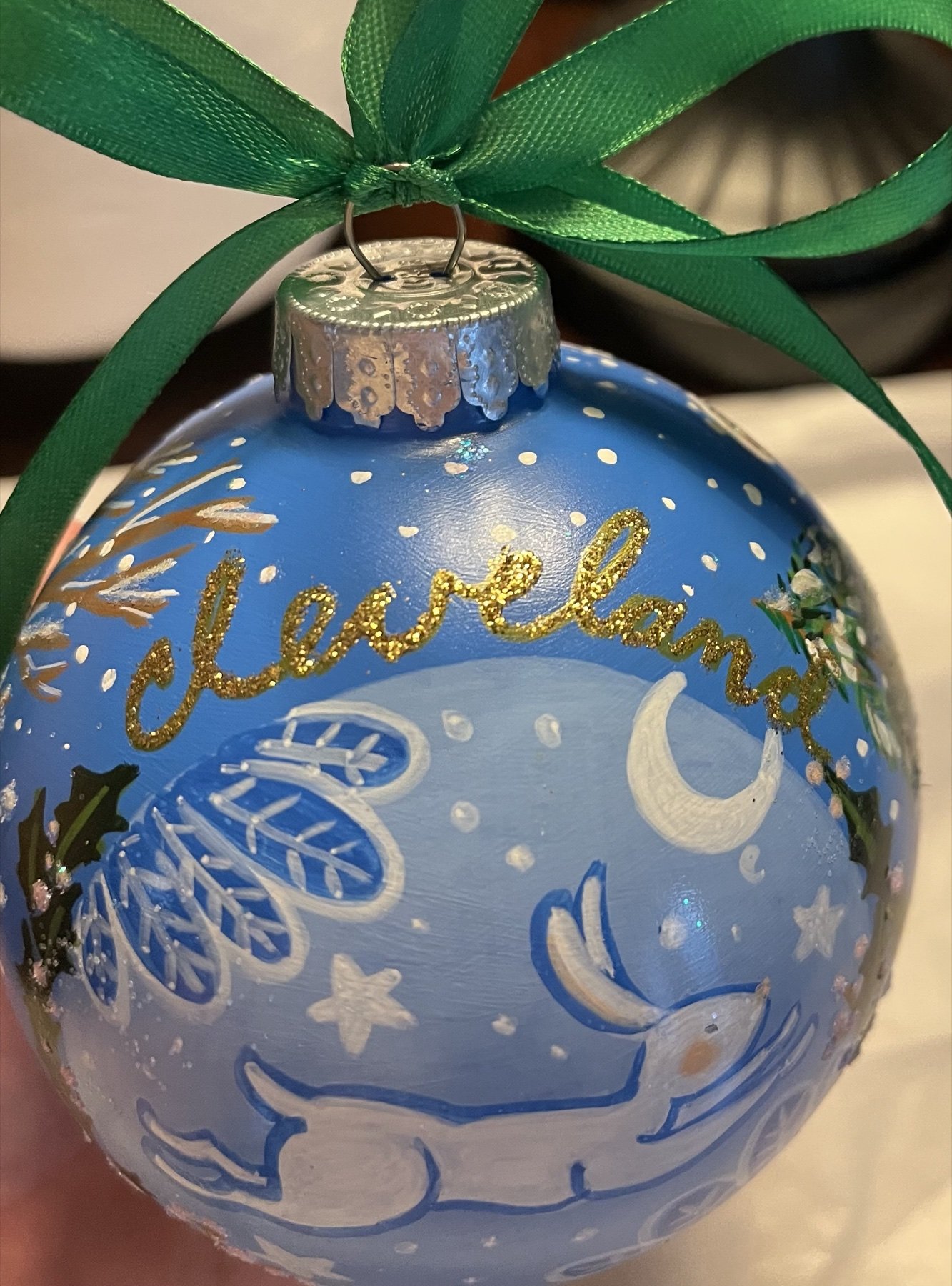 Reverse of a blue Cleveland ornament painted with moon, stars, and a white rabbit