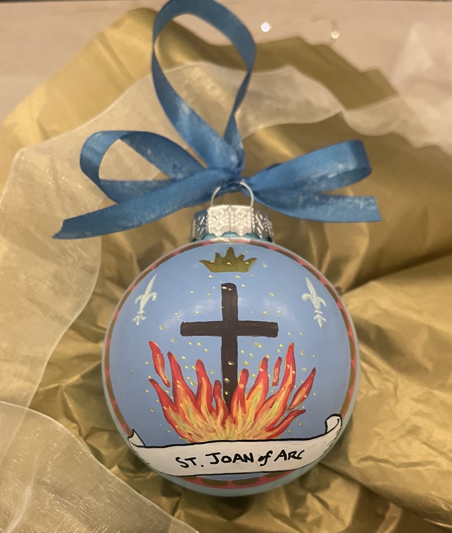 Reverse of a St. Joan of Arc ornament painted with a cross and flames